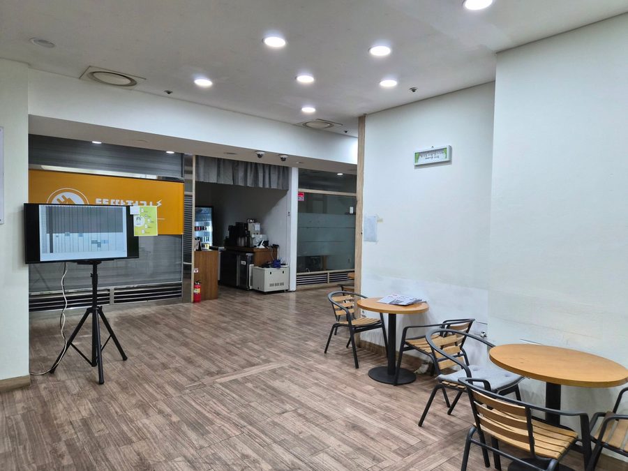센터 앞 공용 공간 — 테이블과 의자가 놓여 있다